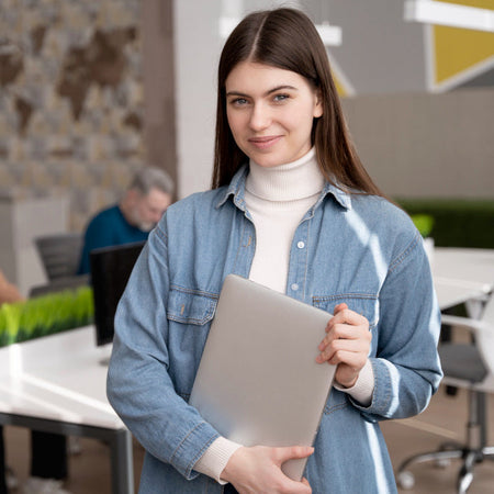 Woman holding a folder in an office setting with colleagues in the background
