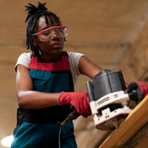 Person using a power tool on a wooden surface