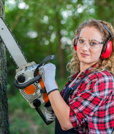 Person using a chainsaw on a tree in a forest setting