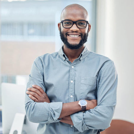 Man wearing glasses and a light blue shirt standing in an office setting