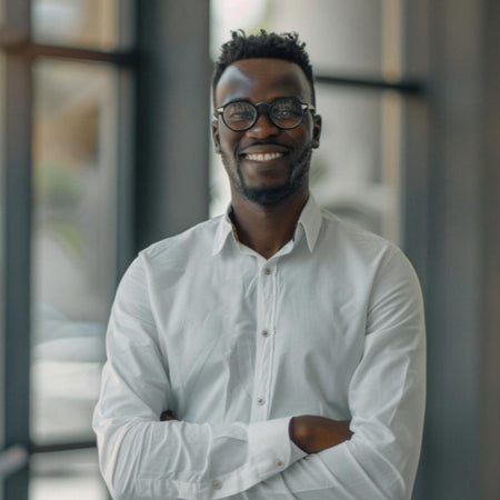 Man wearing glasses and a light shirt standing in an office setting