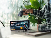 Person using a power drill with a box of Draper tools on a desk.